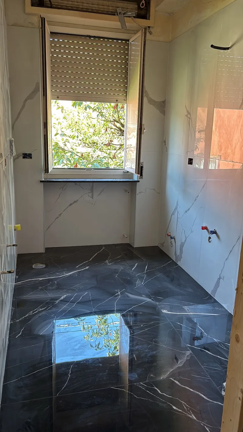 Bagno moderno ristrutturato con piastrelle in gres porcellanato, doccia walk-in e sanitari sospesi.